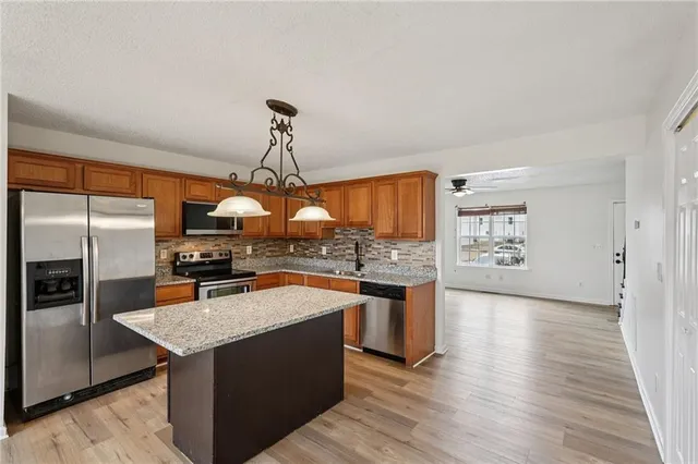 a kitchen with stainless steel appliances granite countertop a sink stove and refrigerator