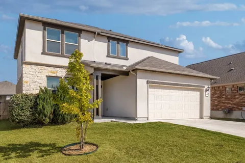 a front view of a house with plants