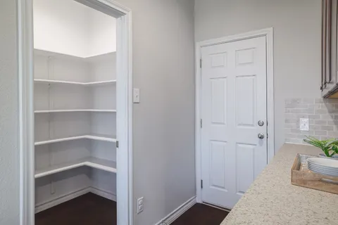 a view of a hallway with wooden floor and entryway