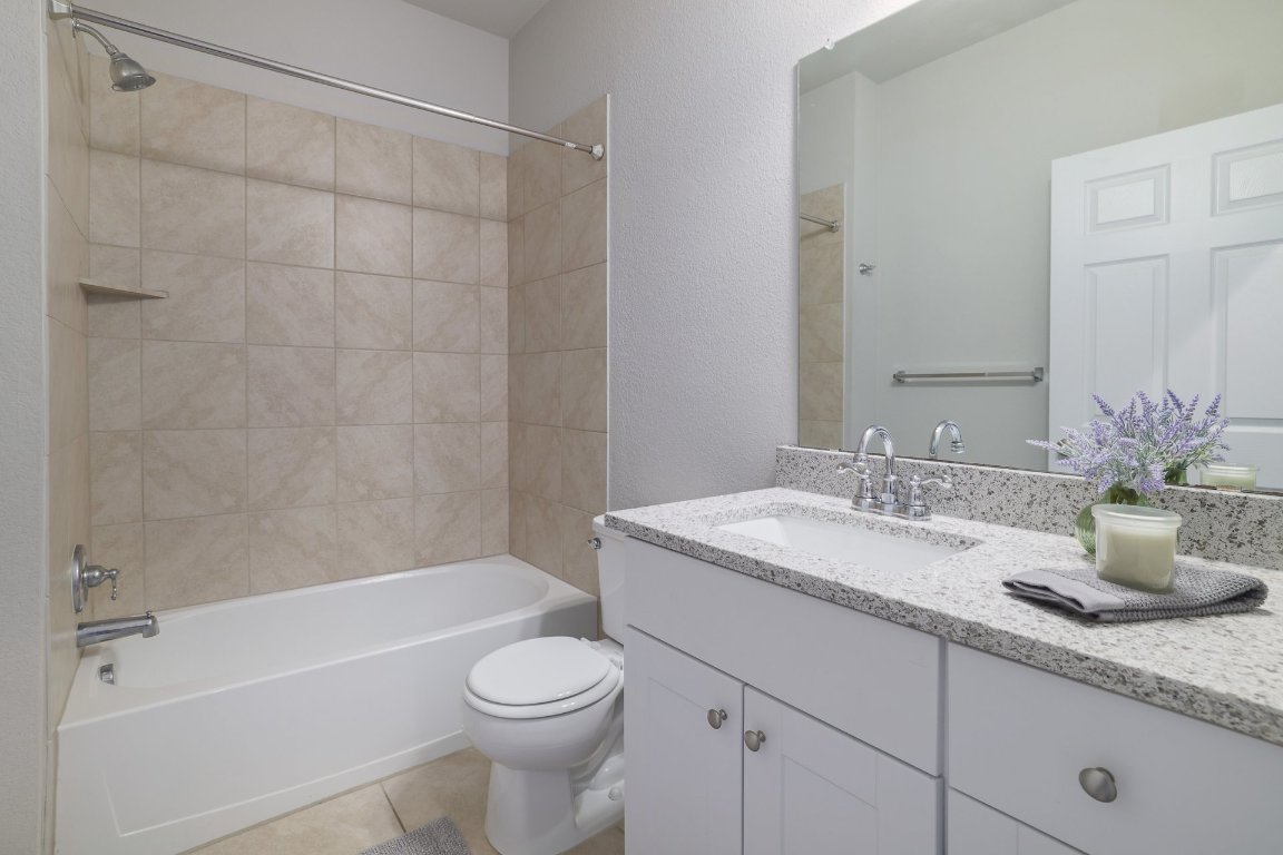 6792 Catania Loop Round Rock, TX 78665 - Photo 23 of 31 a bathroom with a granite countertop sink a toilet and shower
