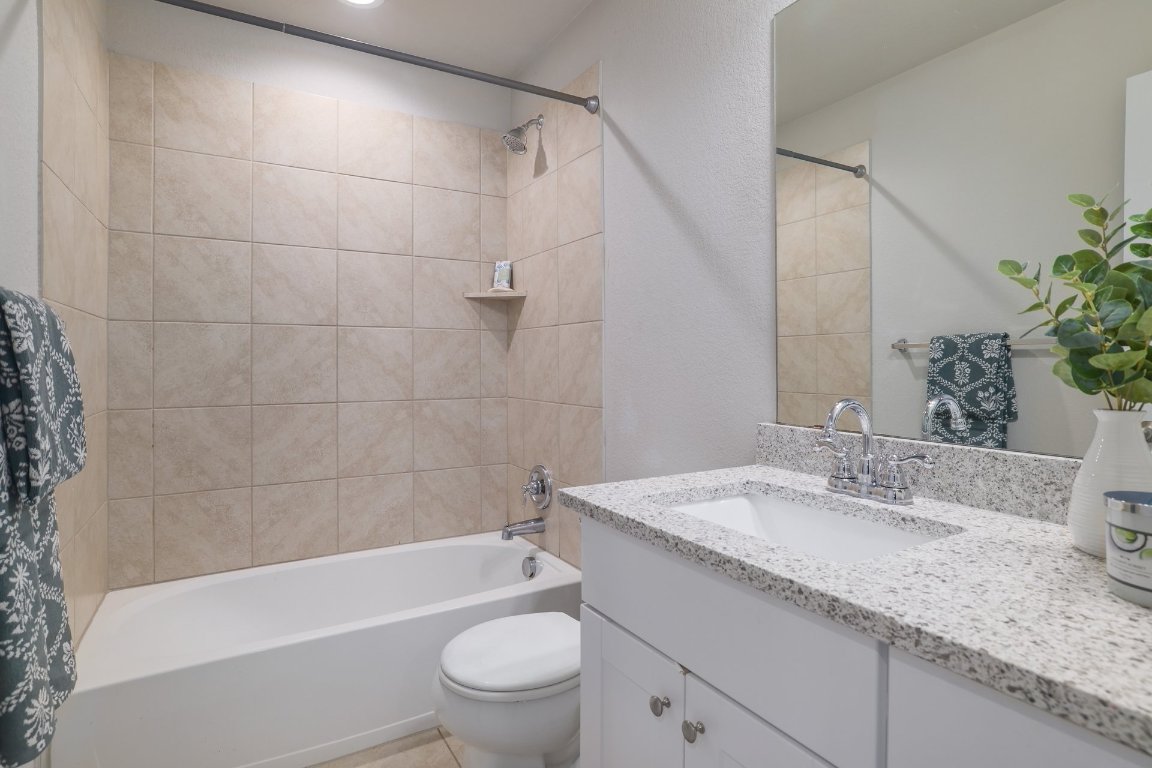 6792 Catania Loop Round Rock, TX 78665 - Photo 25 of 31 a bathroom with a granite countertop sink a toilet and bathtub