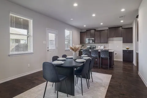 a kitchen with kitchen island granite countertop wooden cabinets and a refrigerator