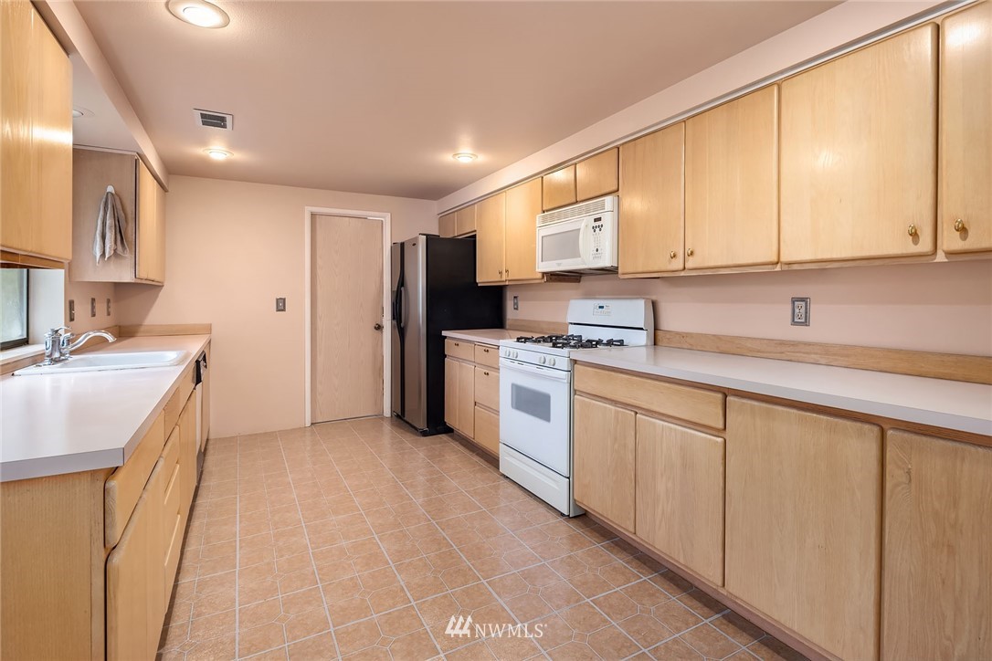 19115 Southeast 128th Street Renton, WA 98059 - Photo 11 of 21 a kitchen with stainless steel appliances sink cabinets and a window