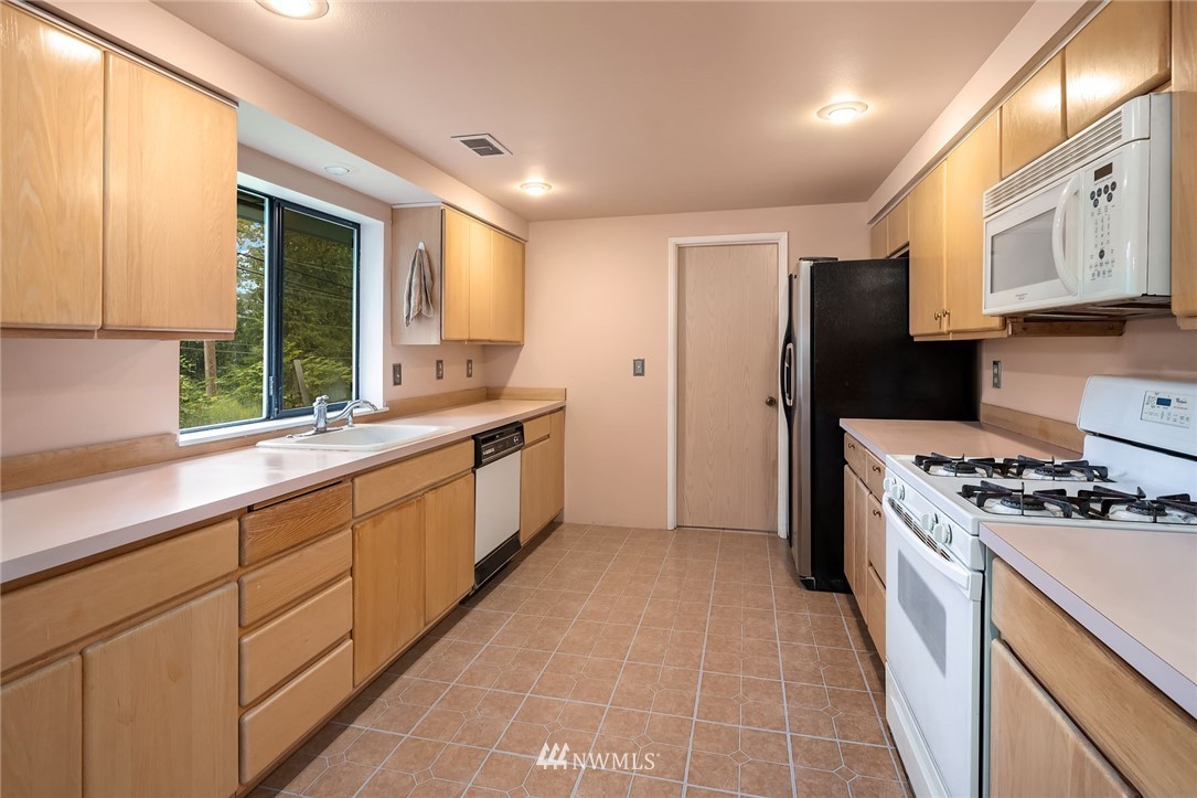19115 Southeast 128th Street Renton, WA 98059 - Photo 12 of 21 a kitchen with stainless steel appliances granite countertop a stove a sink and a refrigerator