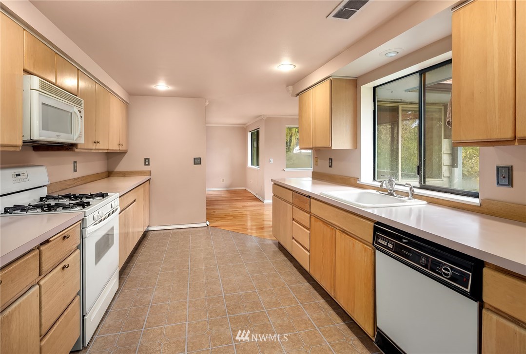 19115 Southeast 128th Street Renton, WA 98059 - Photo 13 of 21 a large kitchen with stainless steel appliances granite countertop a stove a sink and a microwave