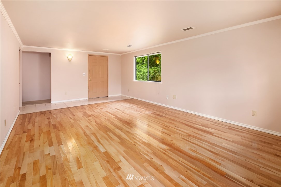 19115 Southeast 128th Street Renton, WA 98059 - Photo 8 of 21 a view of an empty room with wooden floor and a window