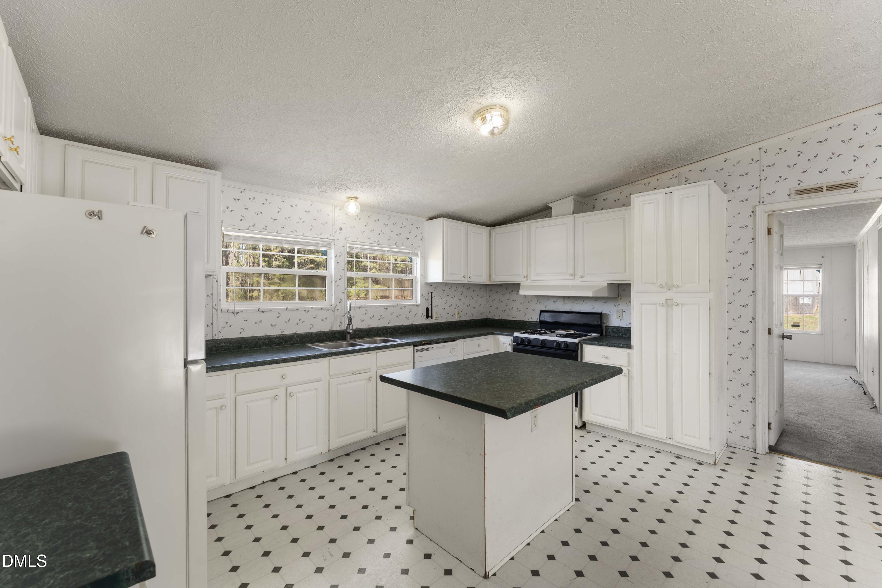 501 Macon-Embro Road Macon, NC 27551 - Photo 5 of 37 a kitchen with granite countertop a sink a stove a refrigerator and white cabinets