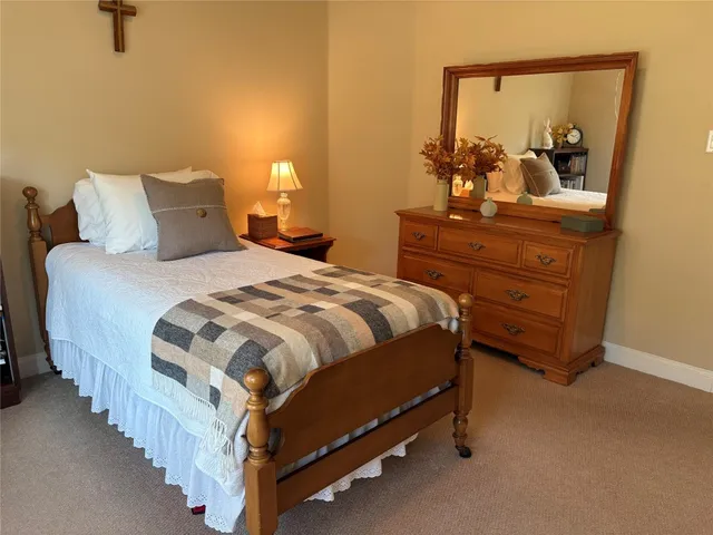 a bedroom with a bed a book shelf and a shelf