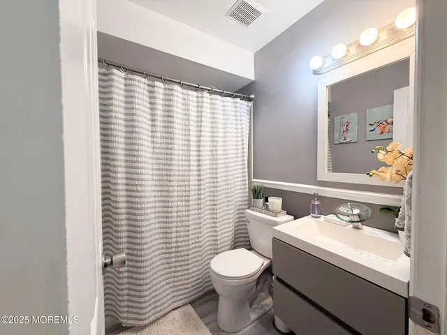 a bathroom with a sink a toilet and mirror