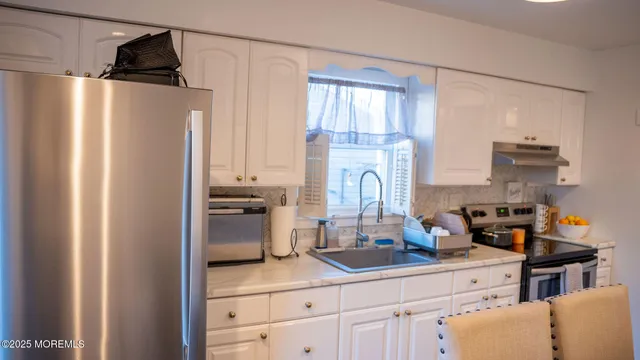 a kitchen with a refrigerator and a stove top oven