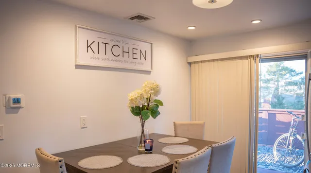 a view of a dining room with furniture and a potted plant