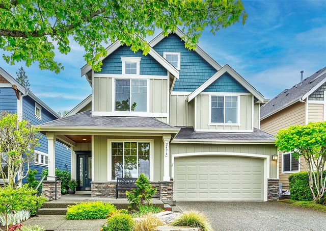 a front view of a house with a yard and garage
