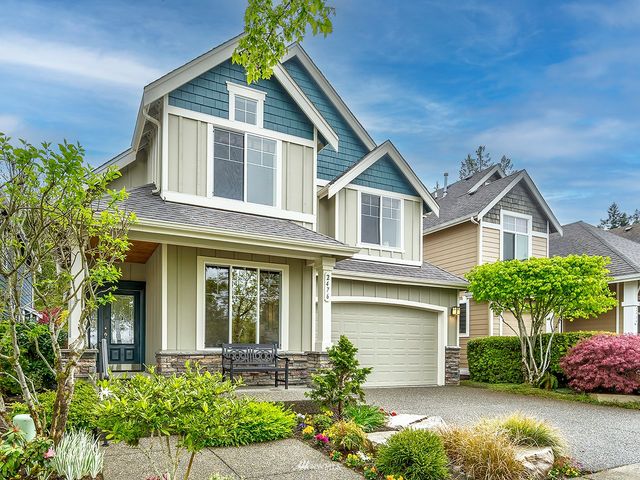 a front view of a house with a yard and potted plants
