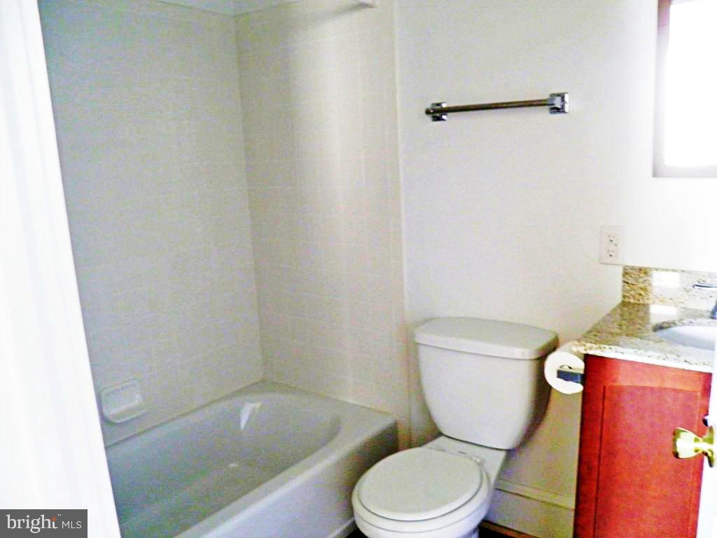 102 East A Street Brunswick, MD 21716 - Photo 14 of 18 a white toilet sitting next to a bath tub