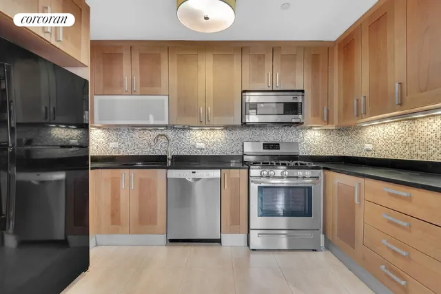 a kitchen with stainless steel appliances granite countertop a stove a sink and a microwave
