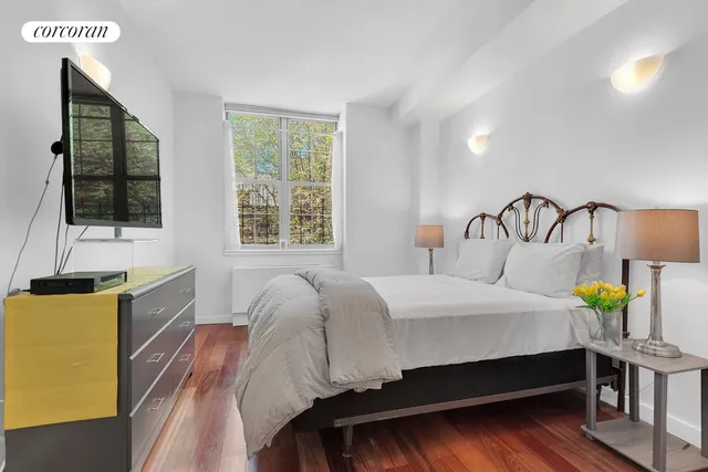 a bedroom with a bed a dresser next to a window