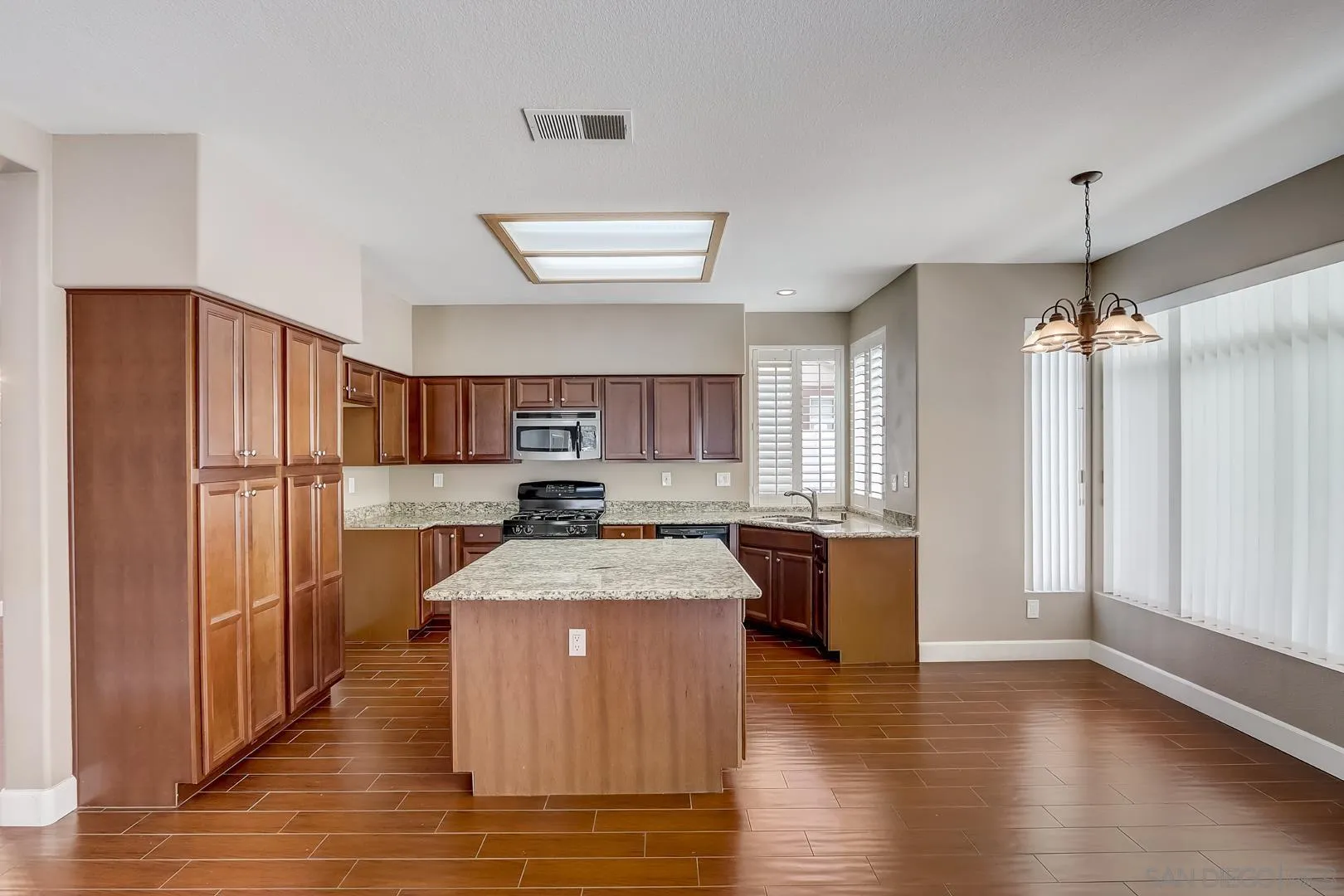4824 Contour Court Oceanside, CA 92057 - Photo 25 of 32 a kitchen with stainless steel appliances granite countertop a refrigerator a sink dishwasher a stove and a refrigerator with wooden floor