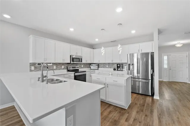a kitchen with white cabinets and stainless steel appliances