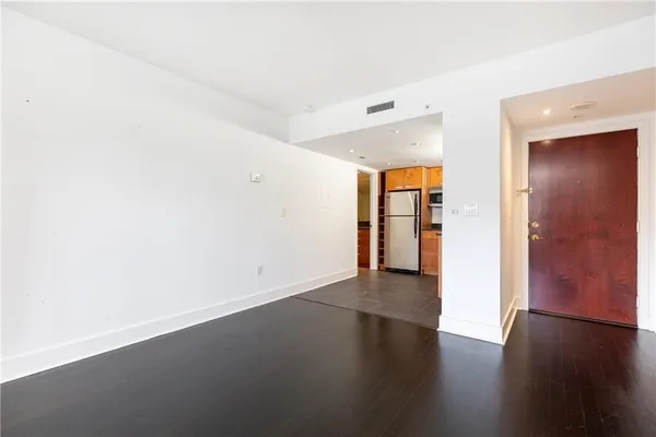 an empty room with wooden floor & windows