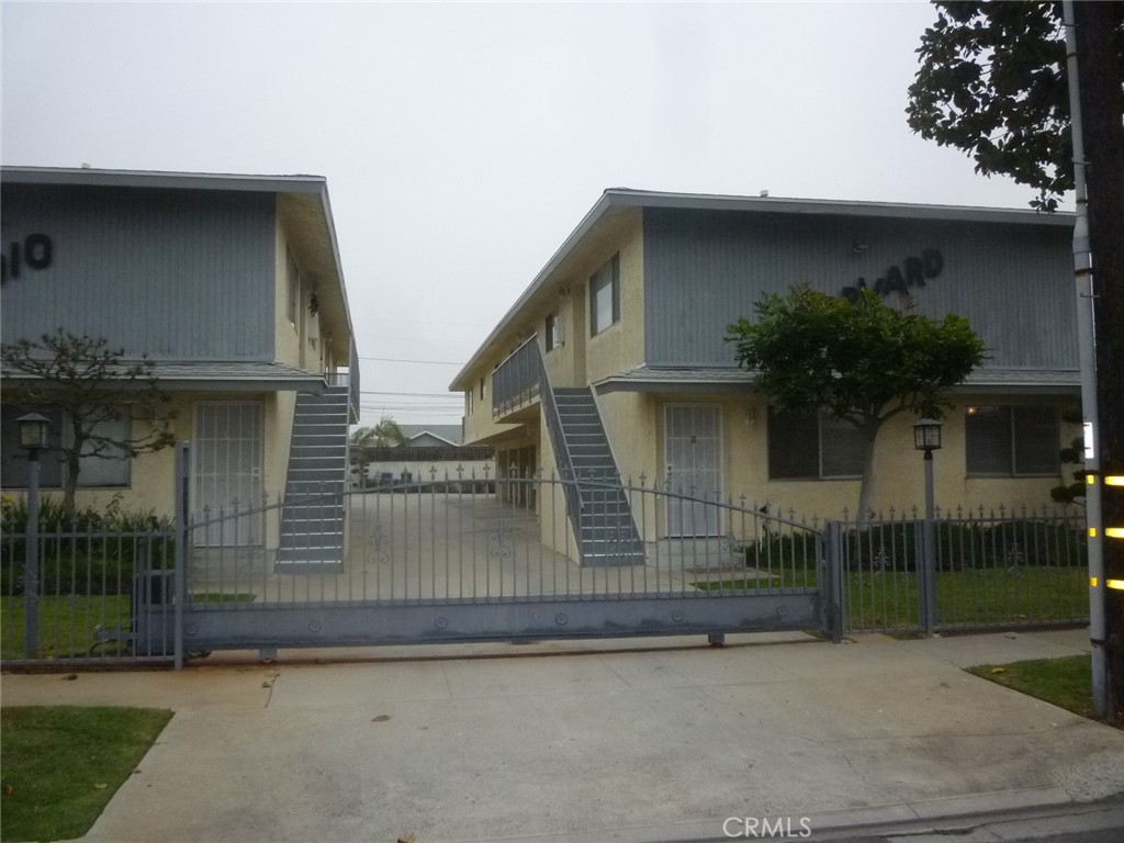 a view of a house with a small yard and potted plants