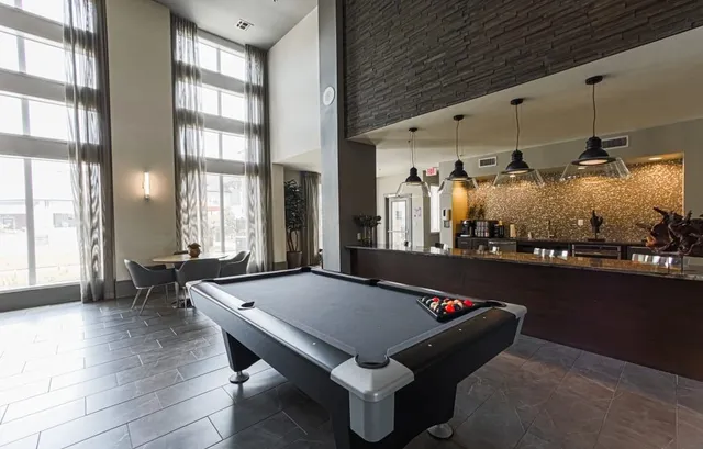 a room with pool table and windows