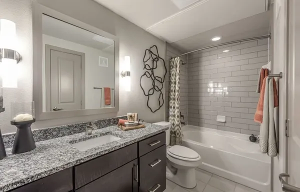 a bathroom with a granite countertop sink toilet and shower