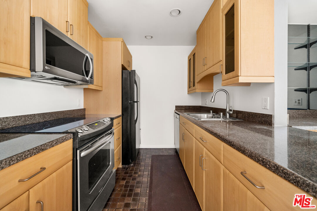 1302 Raintree Circle Culver City, CA 90230 - Photo 11 of 32 a kitchen with stainless steel appliances granite countertop a sink a stove a microwave and wooden cabinets