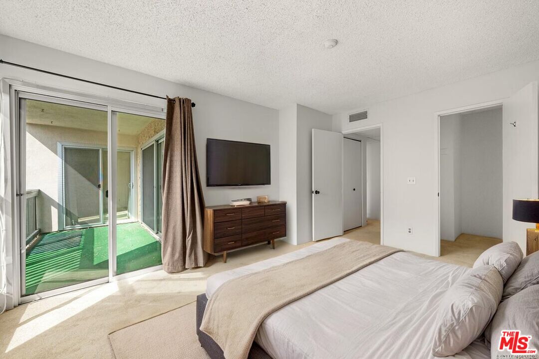 1302 Raintree Circle Culver City, CA 90230 - Photo 7 of 32 a bedroom with a bed and a flat screen tv