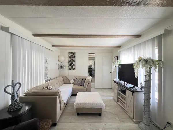 a living room with furniture a flat screen tv and a large window