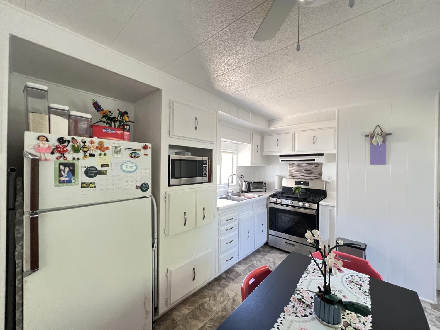 9060 Auburn Folsom Road, Unit 36 Granite Bay, CA 95746 - Photo 6 of 14 a kitchen with stainless steel appliances a refrigerator sink and cabinets