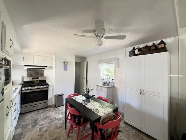 a kitchen with stainless steel appliances a stove a refrigerator and a dining table