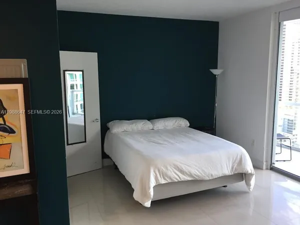a large bed sitting in a bedroom next to a window