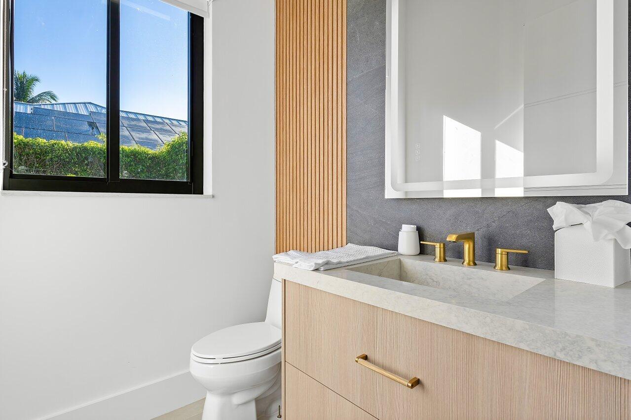 636 Eddy Street Boca Raton, FL 33487 - Photo 24 of 44 a bathroom with a granite countertop sink a toilet and a window