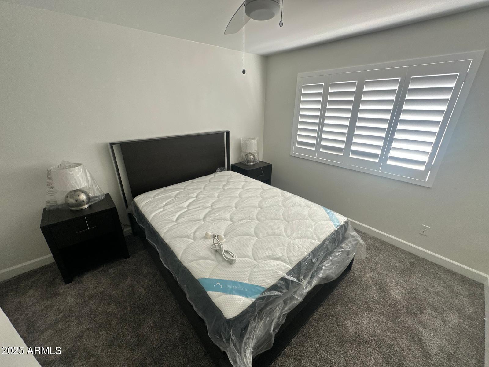 4311 West Sandra Circle Glendale, AZ 85308 - Photo 13 of 19 a bed sitting in a bedroom next to a window