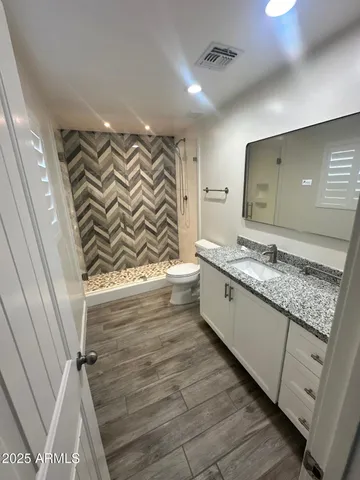 a bedroom with a bed a flat screen tv and a fireplace