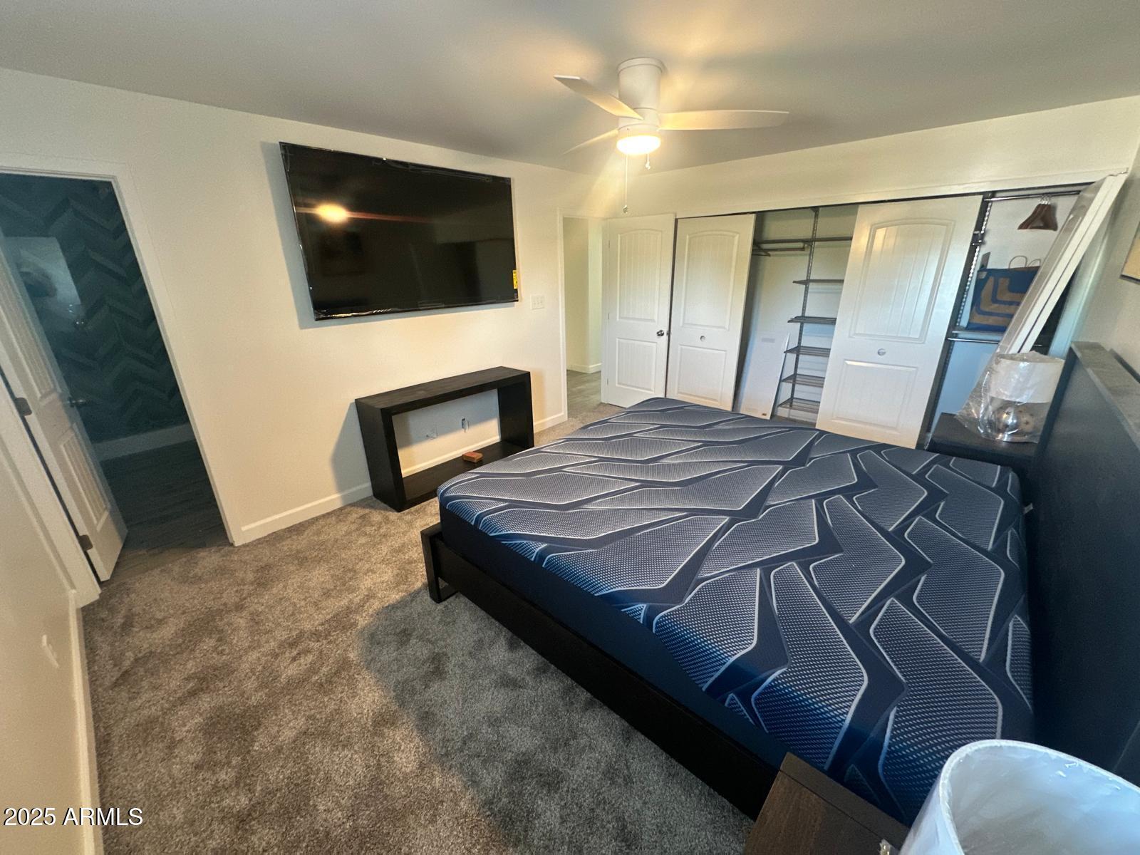 4311 West Sandra Circle Glendale, AZ 85308 - Photo 15 of 19 a bedroom with a bed a flat screen tv and a fireplace