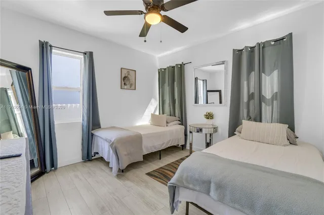 a bedroom with three beds and a window