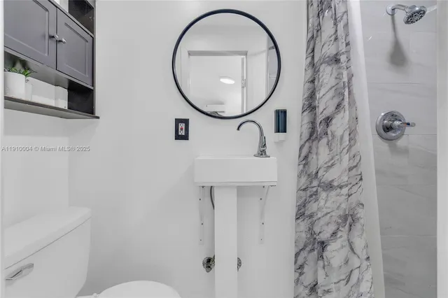 a bathroom with a sink a toilet and a mirror