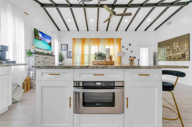 a kitchen with stainless steel appliances kitchen island granite countertop a stove and a sink