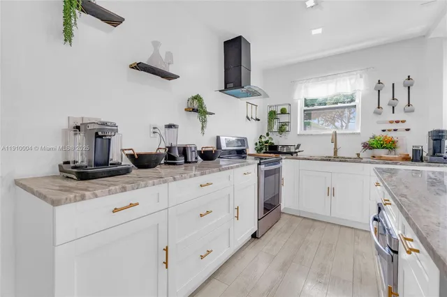 a kitchen with cabinets appliances a sink and a counter top space