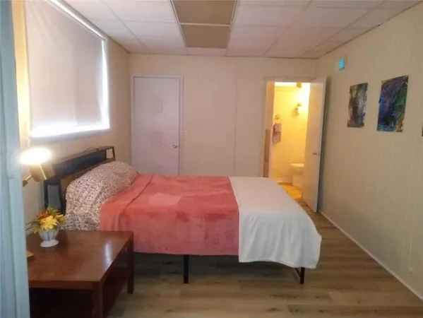 a bedroom with a bed and wooden floor