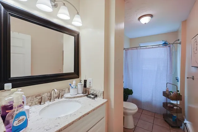 a bathroom with a granite countertop sink a toilet and a mirror