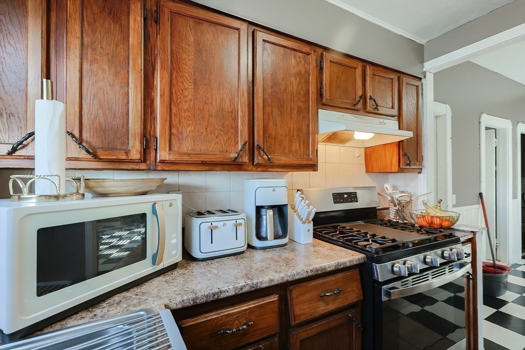 105 16th Street Fall River, MA 02723 - Photo 17 of 31 a kitchen with wooden cabinets and a stove top oven