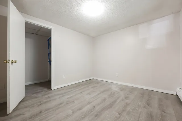 an empty room with wooden floor and closet