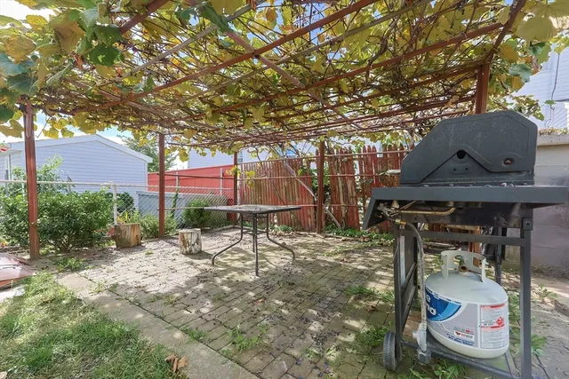 a patio with table and chairs under an umbrella