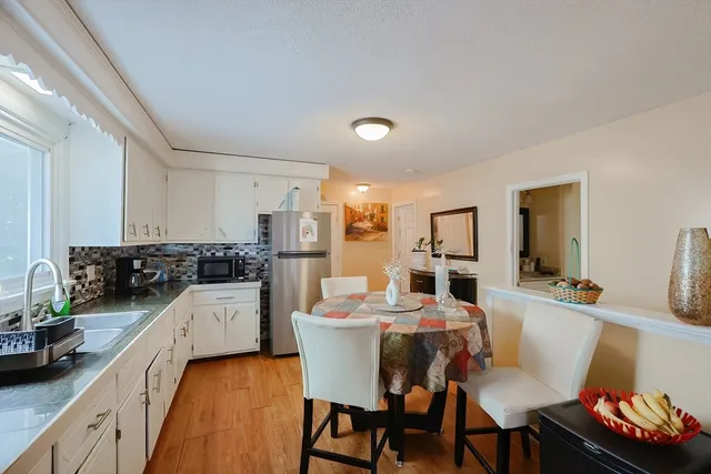 a kitchen with a dining table chairs and white cabinets