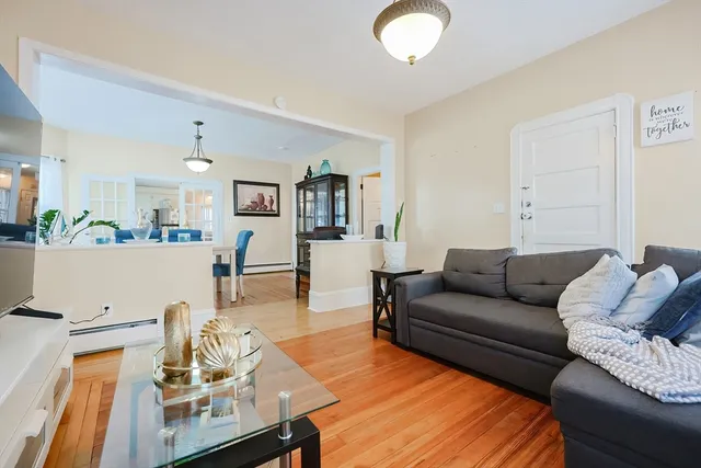a living room with furniture and a wooden floor