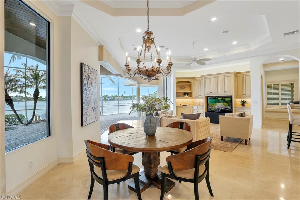 2050 Kingfish Road Naples, FL 34102 - Photo 13 of 35 a dining room with furniture a chandelier and wooden floor