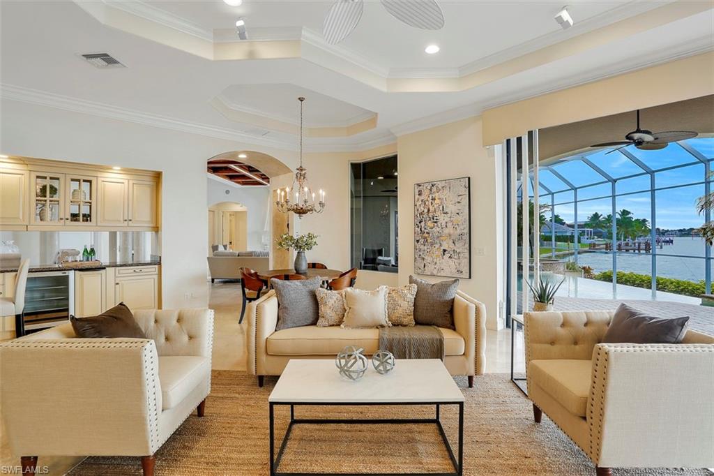 2050 Kingfish Road Naples, FL 34102 - Photo 15 of 35 a living room with furniture a rug and a chandelier