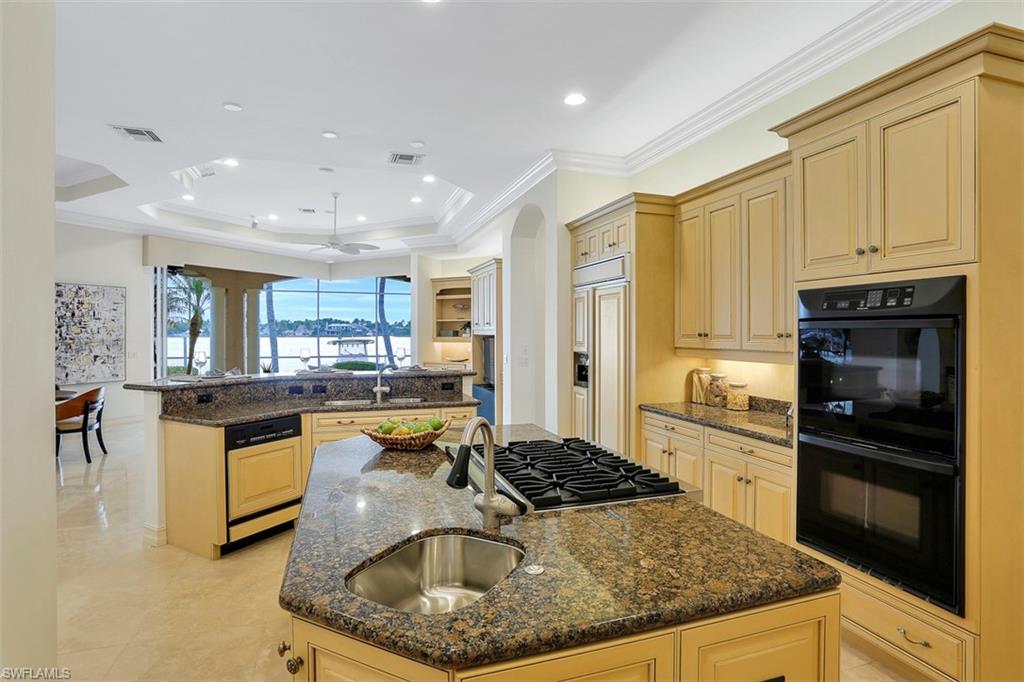 2050 Kingfish Road Naples, FL 34102 - Photo 19 of 35 a kitchen with kitchen island granite countertop a sink stove and refrigerator